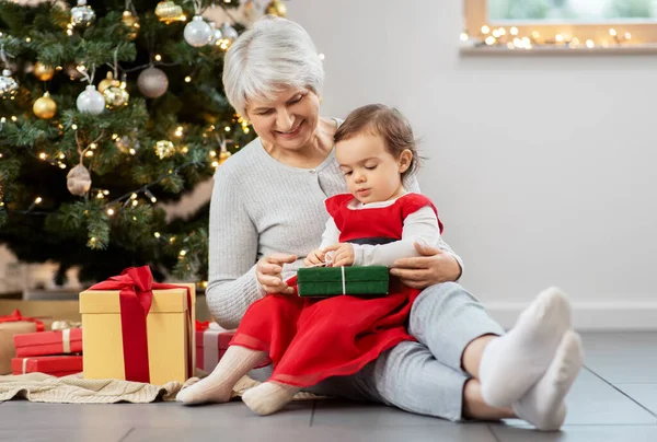 Großmutter und kleines Mädchen mit Weihnachtsgeschenken — Stockfoto