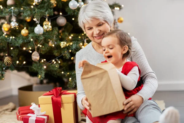 Mormor och liten flicka med julklappar — Stockfoto