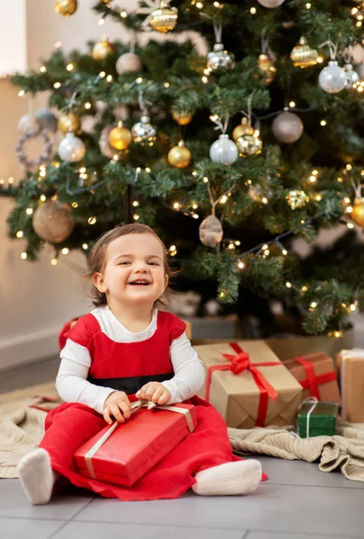 Gelukkig baby meisje opening kerstcadeaus thuis — Stockfoto