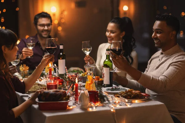 Szczęśliwi przyjaciele pijący wino na przyjęciu świątecznym — Zdjęcie stockowe