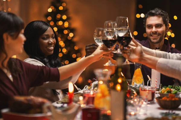 Amigos felizes bebendo vinho na festa de Natal — Fotografia de Stock