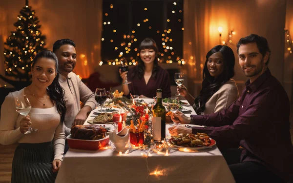 Amigos felizes bebendo vinho na festa de Natal — Fotografia de Stock