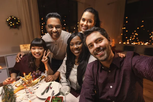 Amigos tomando selfie no jantar de Natal em casa — Fotografia de Stock