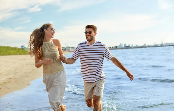夏のビーチを走る幸せなカップルは — ストック写真