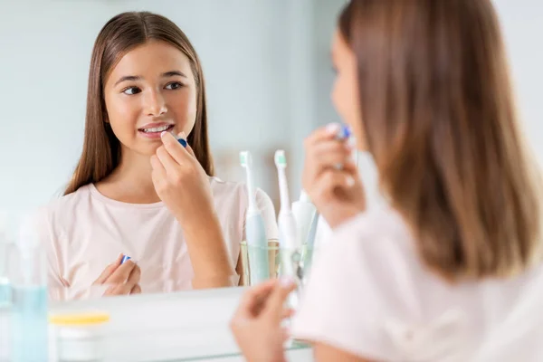 Teenage girl applying lip balm at bathroom — Stock Photo, Image