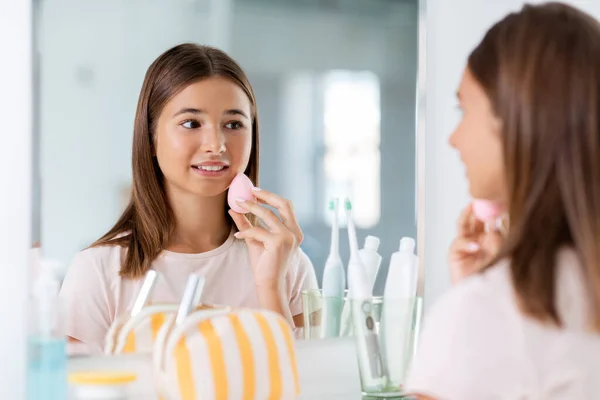 Teenage girl applying foundation to face — Stock Photo, Image