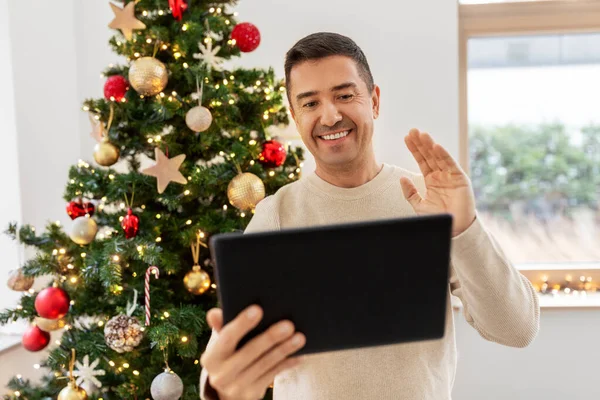 Hombre con la tableta pc tener videollamada en Navidad —  Fotos de Stock