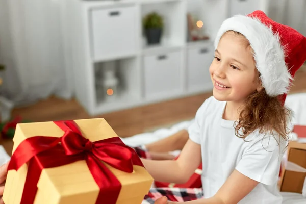 Glückliches Mädchen mit Weihnachtsgeschenk zu Hause — Stockfoto