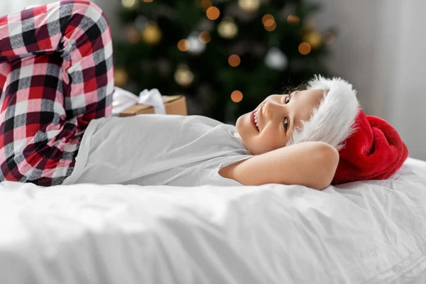 Happy girl with christmas gift on bed at home — Stock Photo, Image