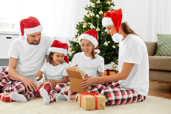 Feliz familia abriendo regalos de Navidad en casa — Foto de Stock