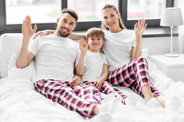 Glückliche Familie im Schlafanzug im Bett am Morgen Stockbild