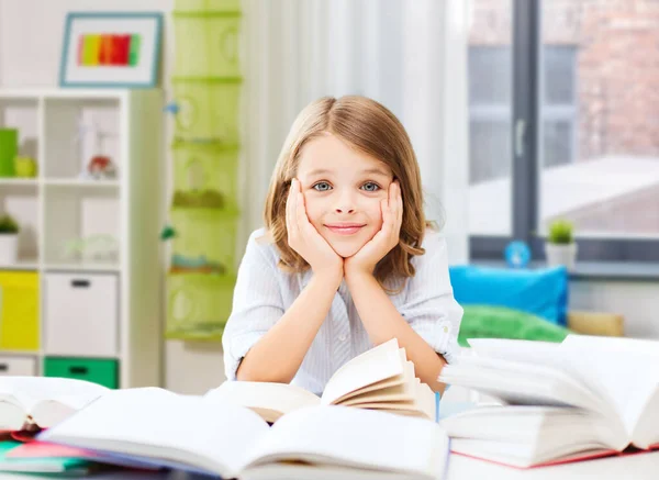 Sonriente estudiante chica leyendo libro en casa — Foto de Stock