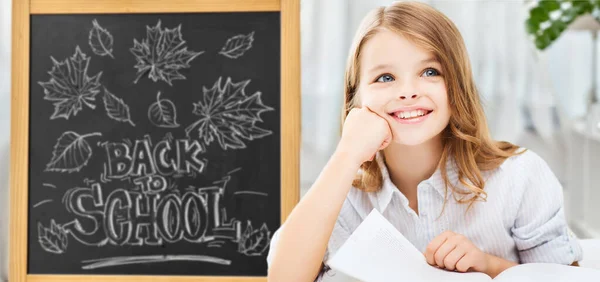 Étudiant fille avec livres sur tableau scolaire — Photo