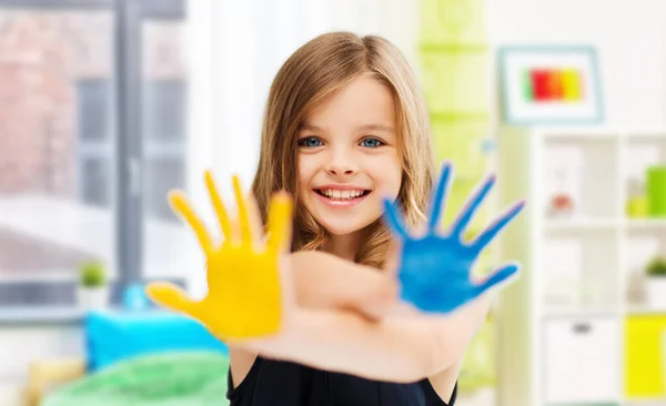 微笑的女孩在家里展示粉刷过的双手 — 图库照片