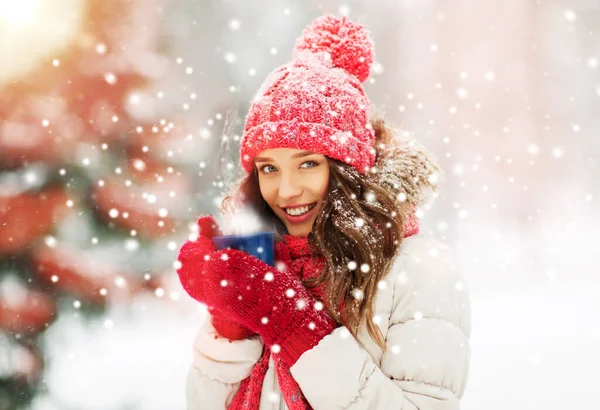 Ευτυχισμένη νεαρή γυναίκα με φλιτζάνι τσαγιού στο χειμερινό πάρκο — Φωτογραφία Αρχείου