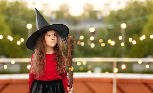 Girl in black witch hat with broom on halloween — Stock Photo, Image