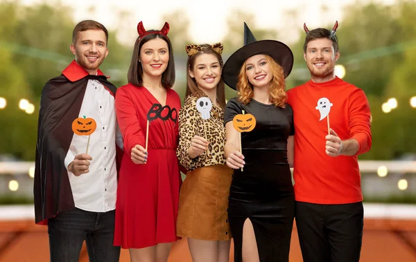 Vänner i halloween kostymer med parti rekvisita — Stockfoto