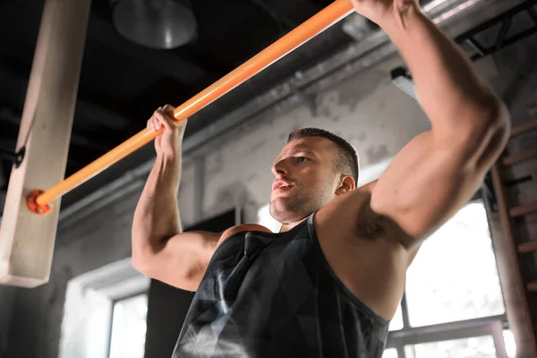 Homme exerçant sur le bar et faisant des pull-ups dans la salle de gym — Photo
