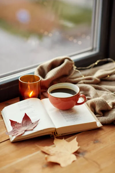 Šálek kávy, kniha na parapetu na podzim — Stock fotografie