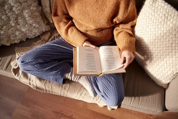 Sıcak kazaklı bir kadın evde kitap okuyor. — Stok fotoğraf