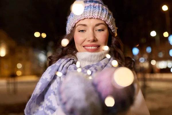 Glückliche junge Frau mit Weihnachtsbeleuchtung — Stockfoto