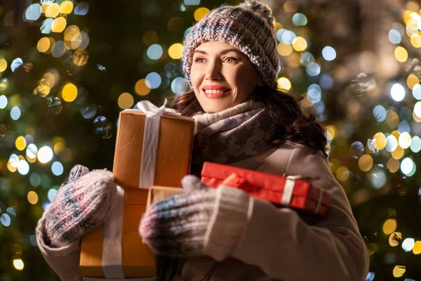 Szczęśliwa kobieta z prezentów świątecznych nad światłami — Zdjęcie stockowe