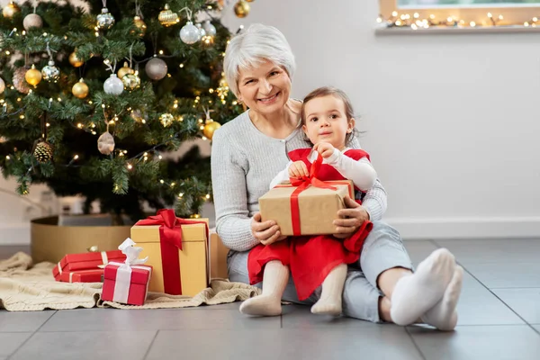 Mormor och liten flicka med julklappar — Stockfoto