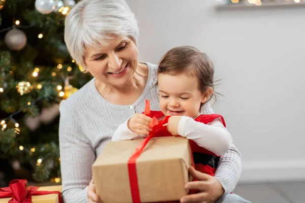 Grandmother and baby girl with christmas gifts — Stock Photo, Image