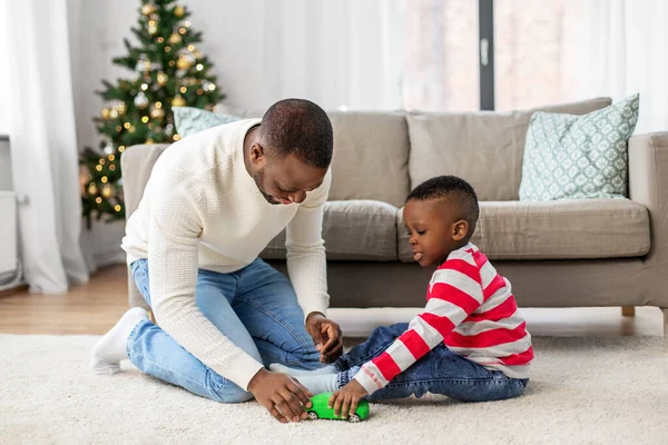 幸せな父親は家でクリスマスに息子と遊ぶ — ストック写真