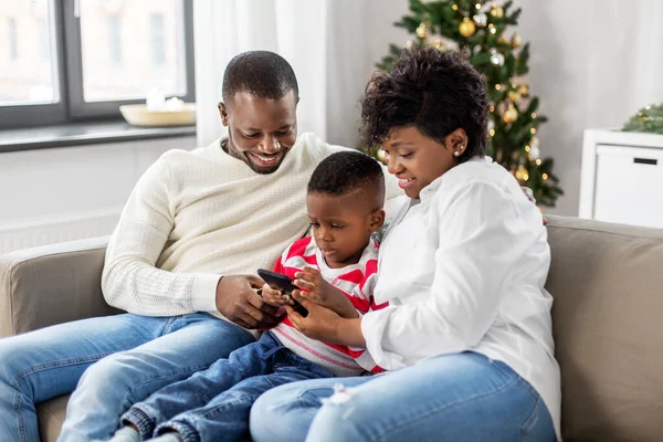 Африканська сім'я з телефоном на Різдво вдома — стокове фото