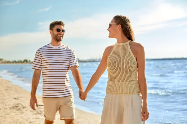 Coppia felice passeggiando lungo la spiaggia estiva — Foto Stock