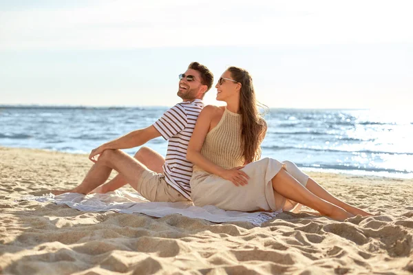 Feliz casal sentado de volta para trás na praia de verão — Fotografia de Stock