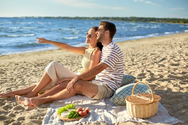 Happy couple having picnic on summer beach — Stock Photo, Image