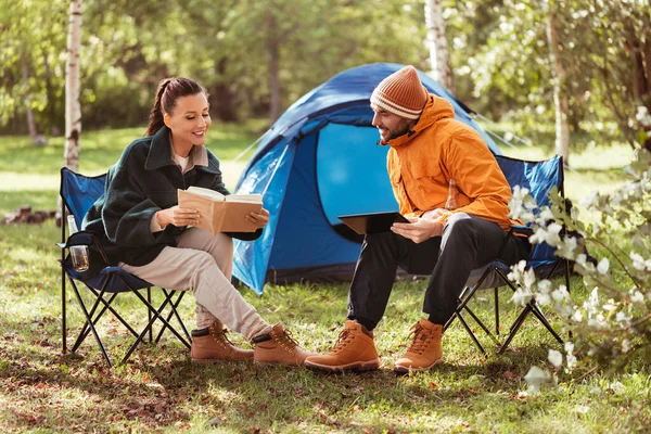 Couple with tablet pc and book at tent camp — Stock Photo, Image