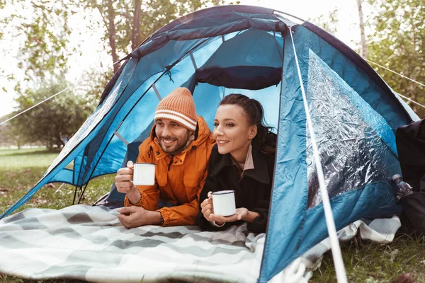 Pari juo teetä makaa sisällä teltta leirintäalueella — kuvapankkivalokuva