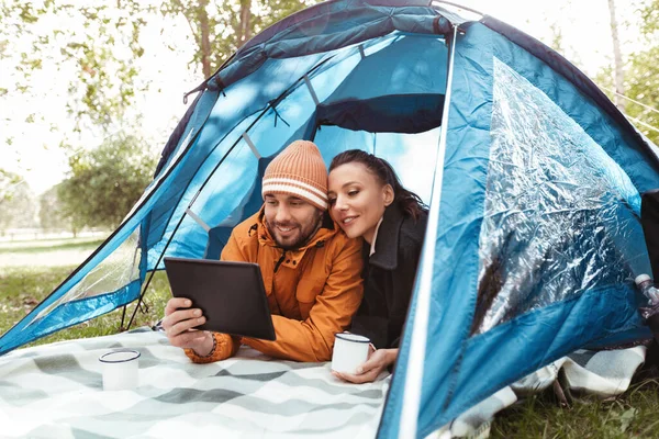 Paar met tablet pc drinken thee binnen tent — Stockfoto