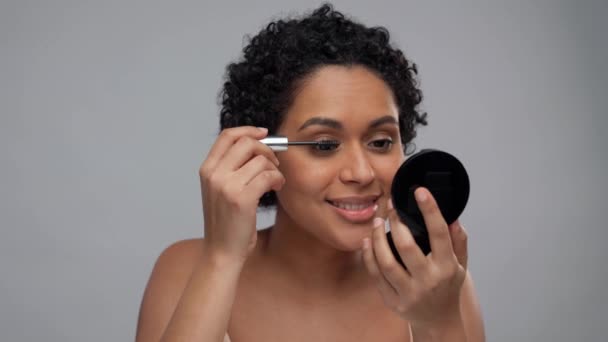 Mooie afrikaanse amerikaanse vrouw toepassen mascara — Stockvideo