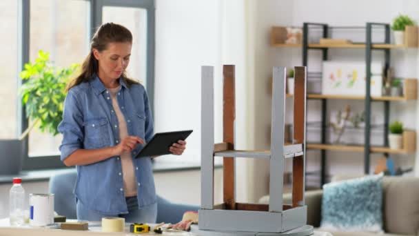 Femme avec tablette pc et table ancienne pour la rénovation — Video