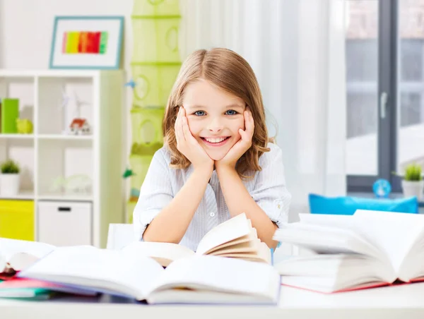 Menina estudante sorrindo com livros aprendendo em casa — Fotografia de Stock