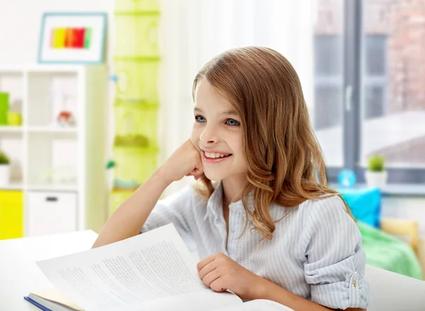 Sorridente studentessa con libro apprendimento a casa — Foto Stock
