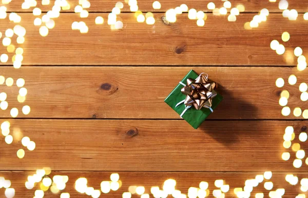 Рождественский подарок на деревянных досках над огнями — стоковое фото