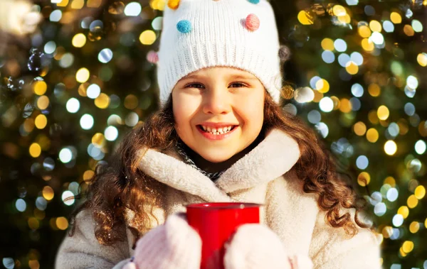 Kış parkında bir fincan sıcak çayla küçük bir kız. — Stok fotoğraf