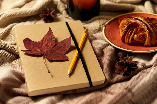 Deník, tužka, skořicová houska a svíčka na podzim — Stock fotografie