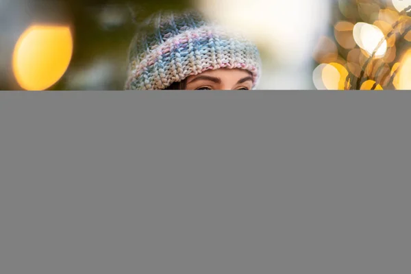 Retrato de feliz jovem mulher em luzes de Natal — Fotografia de Stock