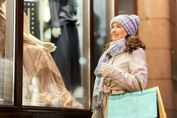 Lycklig kvinna med shoppingväskor på vintern — Stockfoto