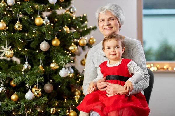 Grandmother and baby girl with at christmas tree — Stock Photo, Image