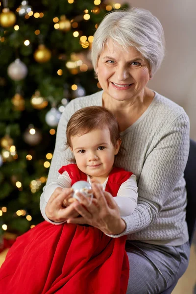 Mormor och liten flicka med vid julgran — Stockfoto