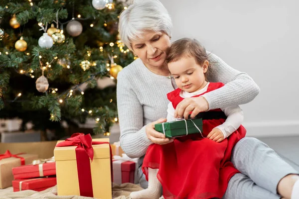Großmutter und kleines Mädchen mit Weihnachtsgeschenken — Stockfoto