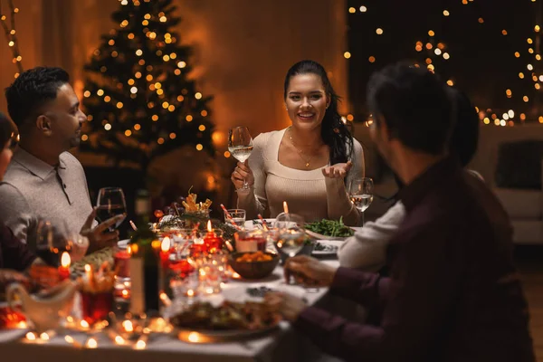 Glada vänner dricka vin på julfesten — Stockfoto