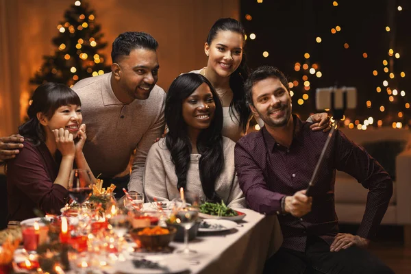 Amigos tomando selfie en la cena de Navidad en casa — Foto de Stock